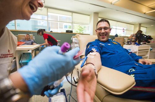 STARS flight paramedic Grant Therrien gives blood as part of the Sirens for Life initiative at the Canadian Blood Services in Winnipeg on Thursday, June 25, 2015. Mikaela MacKenzie / Winnipeg Free Press