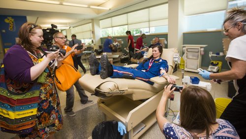 The media surrounds STARS flight nurse Jennifer Fosty as she gives blood as part of the Sirens for Life initiative at the Canadian Blood Services in Winnipeg on Thursday, June 25, 2015. Mikaela MacKenzie / Winnipeg Free Press