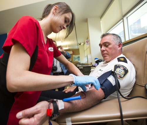 Police superintendent Bruce Ormiston gives blood as part of the Sirens for Life initiative at the Canadian Blood Services in Winnipeg on Thursday, June 25, 2015. Mikaela MacKenzie / Winnipeg Free Press