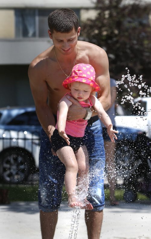 Alexey Maksimov wih his two year daughter Milana cool off on a hot Friday afternoon at the Central Park Spray Pad on Cumberland Ave.  Wayne Glowacki / Winnipeg Free Press June 26  2015
