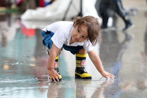 Two-year-old Diezel McMillan plays in the puddles with his rain boots on after a downpour Saturday at the Forks. Standup photo  June 27,, 2015 Ruth Bonneville / Winnipeg Free Press