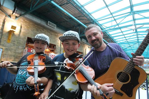 Uptown feature on local group called - Double the Trouble, which is a father and twin sons group here in Winnipeg.  Father, Rob Wrigley, who's been in bands around town for years. plays with his 12-year-old sons, Luc (Left, ACDC shirt)  and Aidan, both fiddlers, Metis folk music and are launching a CD at the Park Theatre on Thursday night,   For July 2 edition of Uptown.  June 27,, 2015 Ruth Bonneville / Winnipeg Free Press