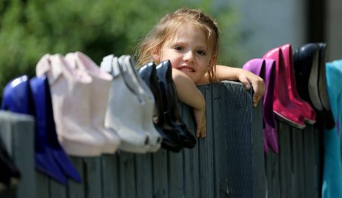 Katrina Thorne, 4, peaks over at a yard sale along Corydon Avenue, Sunday, June 28, 2015. (TREVOR HAGAN/WINNIPEG FREE PRESS)