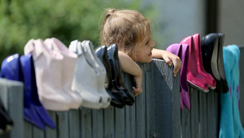 Katrina Thorne, 4, peaks over at a yard sale along Corydon Avenue, Sunday, June 28, 2015. (TREVOR HAGAN/WINNIPEG FREE PRESS)