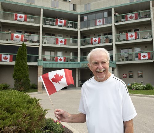 DAVID LIPNOWSKI / WINNIPEG FREE PRESS (June 29, 2015)  Almost every apartment at Agape Villa  (395 Beaverhill Blvd) has a Canadian flag on their balcony. The social committee received a grant for the flags. Grounds keeper Bob Horwood shows off his patriotism Monday June 29, 2015.