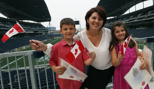 Hysnije Krasnigi with her children Dion,7, at left and Dea,5, originally from Kosovo were among the 100 people that became Canadians at the Citizenship Ceremony in the Pinnacle Club at Investors Group Field Monday. The new Canadians were treated to tickets for the Winnipeg Blue Bombers Home Opener on July 2nd  and will be honoured at the  special half-time presentation with the citizens at centre field. ¤  see release .Wayne Glowacki / Winnipeg Free Press June 29  2015