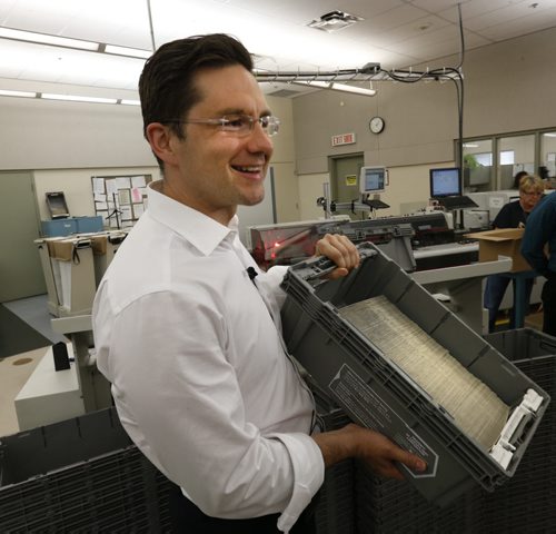 Pierre Poilievre, Minister of Employment and Social Development  holds cheques in evelopes as he tours the insertion room Tuesday at the  Winnipeg Production Centre, where Universal Child Care Benefit cheques are printed  for a portion of eligible families across Canada. The cheques will be mailed and received by families starting July 20th. About 1.2 million cheques will be printed, with production done at centres in Winnipeg and Quebec City. About 2.7million additional UCCB payments will be made via direct deposit, for a total of 3.85million payments. Mia Rabson story  Wayne Glowacki / Winnipeg Free Press June 30  2015