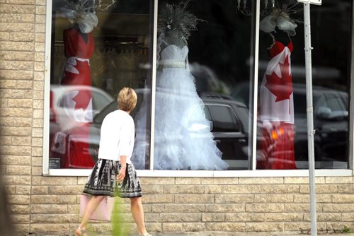 STANDUP - An unidentified walker slides past a Canada Day fashion displayed in the 7th Avenue Fashion shop on Academy. BORIS MINKEVICH/WINNIPEG FREE PRESS June 30, 2015