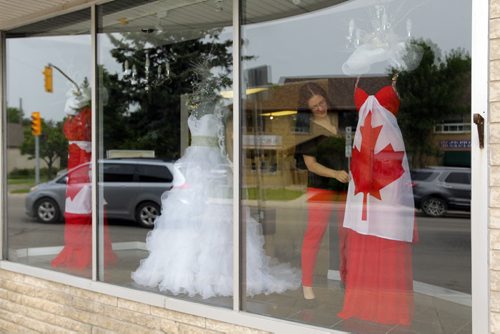 STANDUP - Carly Iskierski does some adjusting to the Canada Day fashion displayed in the 7th Avenue Fashion shop on Academy. BORIS MINKEVICH/WINNIPEG FREE PRESS June 30, 2015