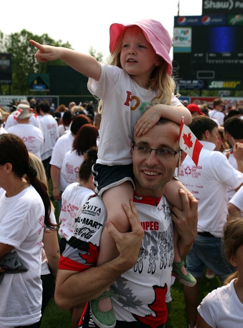 Four year old Ella Andrews gets a great view of the Human Canadian Flag on top of her dad Rod Salm's shoulders at Shaw baeball park. BORIS MINKEVICH/WINNIPEG FREE PRESS July 1, 2015