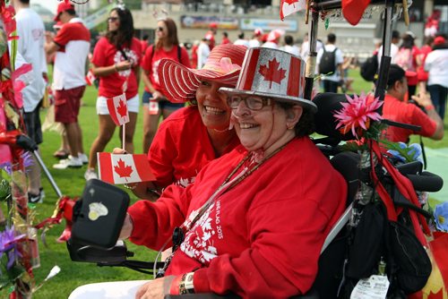 Human Canadian Flag. (R) Olive Yaremko in the Canada Day decorated scooter with (L-back) Elma Ceruma at Shaw baseball park. BORIS MINKEVICH/WINNIPEG FREE PRESS July 1, 2015