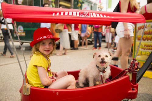Even Groen, 4, gets a ride with her dog at the annual Osborne Street Festival on Wednesday, July 1, 2015. Mikaela MacKenzie / Winnipeg Free Press