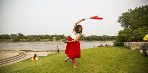 Yzabelle Juayang, 7, dances with her Canadian flag at the Forks on Wednesday, July 1, 2015. Mikaela MacKenzie / Winnipeg Free Press