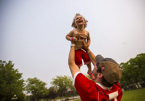 Norah Hall, 2, laughs when her dad lifts her up into the air on Canada Day at the Forks on Wednesday, July 1, 2015. Mikaela MacKenzie / Winnipeg Free Press
