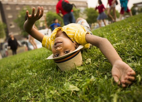 Dharshin Kollayil, 6, rolls down a hill instead of watching the show on Canada Day at the Forks on Wednesday, July 1, 2015. Mikaela MacKenzie / Winnipeg Free Press