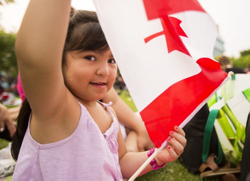 Isabella Baghdoyan, 4, plays with her flag on Canada Day at the Forks on Wednesday, July 1, 2015. Mikaela MacKenzie / Winnipeg Free Press