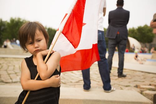 Ryder Duck, 4, sulked as he holds a Canadian flag on Canada Day at the Forks on Wednesday, July 1, 2015. Mikaela MacKenzie / Winnipeg Free Press