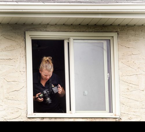 A child is reported to have fallen through the screen of a second storey window to the ground on Ravenhill Rd  Police investigate the scene Thursday from second storey window-Breaking News- July 02, 2015   (JOE BRYKSA / WINNIPEG FREE PRESS)