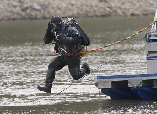 A member of Winnipeg Police Underwater Search and Recovery Unit enters the Red River Thursday  near the end of Burrows Ave. morning where an angler caught a clump of dark brown hair that appeared to be from a human.   Kevin Rollason story.Wayne Glowacki / Winnipeg Free Press July 2  2015