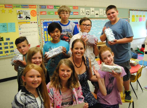 Grade five and six students from Springfield Heights School sold handmade paper brick firestarters to raise money for the Sunshine Fund with help from instructor, Kelly Allen (fourth from right). (Jessica Botelho-Urbanski / Winnipeg Free Press)