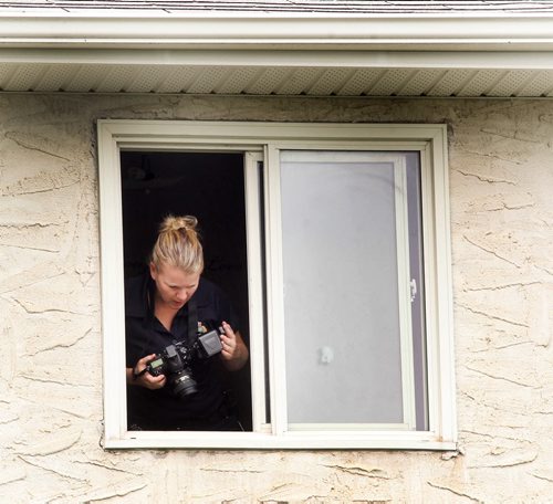 A child is reported to have fallen through the screen of a second storey window to the ground on Ravenhill Rd  Police investigate the scene Thursday from second storey window-Breaking News- July 02, 2015   (JOE BRYKSA / WINNIPEG FREE PRESS)