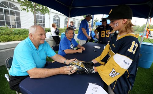 Dave Ritchie, signing an autograph for Matt Stephens, 11, from Brandon, with Trevor Kennerd and Danny McManus, July 2, 2015. (TREVOR HAGAN/WINNIPEG FREE PRESS)