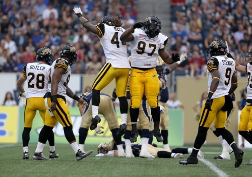Hamilton Tiger-Cats'  Taylor Reed (44) and Ted Laurent (97) celebrate after Taylor Reed (44) and Adrian Tracy (93) sacked Winnipeg Blue Bombers' quarterback Drew Willy (5). Willy would be hurt on the play and be forced to leave the game. Thursday, July 2, 2015. (TREVOR HAGAN/WINNIPEG FREE PRESS)