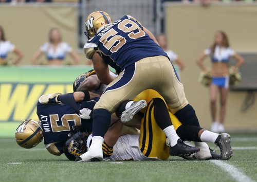 Hamilton Tiger-Cats'  Taylor Reed (44) and Ted Laurent (97) sack Winnipeg Blue Bombers' quarterback Drew Willy (5). Willy would be hurt on the play and be forced to leave the game. Thursday, July 2, 2015. (TREVOR HAGAN/WINNIPEG FREE PRESS)