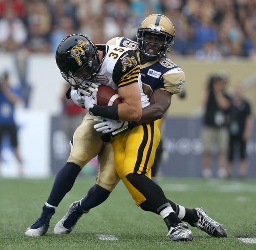 Winnipeg Blue Bombers' Clarence Denmark (89) has to tackle Hamilton Tiger-Cats' Mike Daly (35) after he catches an interception during first half CFL action, Thursday, July 2, 2015. (TREVOR HAGAN/WINNIPEG FREE PRESS)