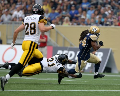 Winnipeg Blue Bombers' Paris Cotton (34) evades a tackle and scores an early touchdown against the Hamilton Tiger-Cats'  during first half CFL action, Thursday, July 2, 2015. (TREVOR HAGAN/WINNIPEG FREE PRESS)
