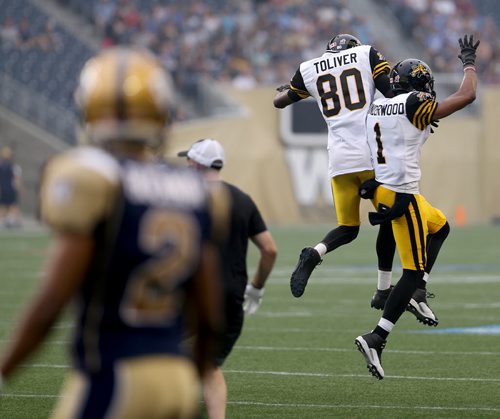 Hamilton Tiger-Cats'  Terrence Toliver (80) and Tiquan Underwood (1) celebrate after Toliver scored against the Winnipeg Blue Bombers' during first half CFL action, Thursday, July 2, 2015. (TREVOR HAGAN/WINNIPEG FREE PRESS)
