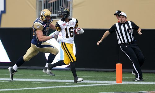 Hamilton Tiger-Cats' Brandon Banks scores a touchdown with Winnipeg Blue Bombers' Tim Cronk (36) giving chase, during first half CFL action, Thursday, July 2, 2015. (TREVOR HAGAN/WINNIPEG FREE PRESS)