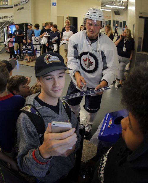Brendan Lemeiux signs autographs for the kids after he got off the ice at The Winnipeg Jets 2015 Development Camp at MTS Iceplex. Here he gets a selfie with an unnamed kids. BORIS MINKEVICH/WINNIPEG FREE PRESS July 3, 2015