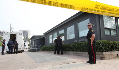 Police officers take a close look at the window using a flashlight which appears to be broken and blood sprayed on it at Petersen and King Law Office at 252 River Ave. where a bomb exploded Friday morning.   See story.  July 03,, 2015 Ruth Bonneville / Winnipeg Free Press