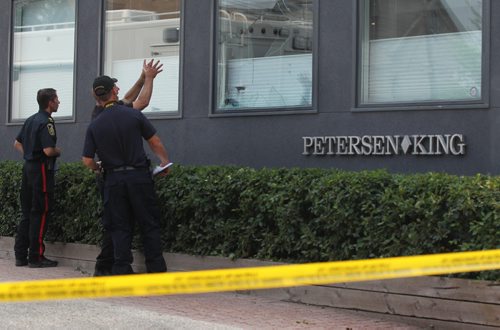 A Police officer uses hand movements as he talks with a fellow officer while they take a closer look at the broken window which appears to have blood sprayed on it at Petersen and King Law Office at 252 River Ave. where a bomb exploded Friday morning.   See story.  July 03,, 2015 Ruth Bonneville / Winnipeg Free Press