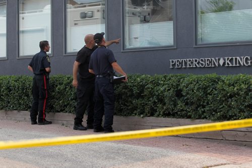 A Police Officer points to the broken window which appears to have blood on it  as he talks with a fellow officer while they take a closer look at Petersen and King Law Office at 252 River Ave. where a bomb exploded Friday morning.   See story.  July 03,, 2015 Ruth Bonneville / Winnipeg Free Press
