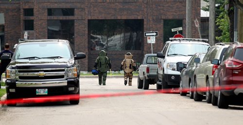 Two members of the bomb squad unit make their way into a building on River Ave. Friday afternoon after a bomb went off in the hands of a worker at 252 River on Friday morning. Streets in area  blocked off for hours. See story.  July 03,, 2015 Ruth Bonneville / Winnipeg Free Press