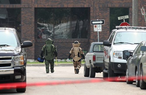 Two members of the bomb squad unit make their way into a building on River Ave. Friday afternoon after a bomb went off in the hands of a worker at 252 River on Friday morning. Streets in area  blocked off for hours. See story.  July 03,, 2015 Ruth Bonneville / Winnipeg Free Press