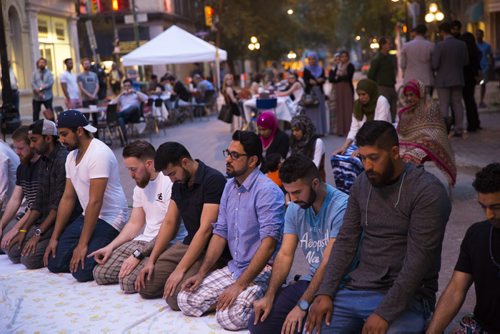 People pray before breaking the Ramadan fast at the Fast and Furious Feast in the Exchange District in Winnipeg on Friday, July 3, 2015. Mikaela MacKenzie / Winnipeg Free Press