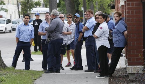 Evacuated Postal workers wait outside as emergency personnel attend to the Winnipeg Downtown Canada Postal building on McDermot Ave. and Frances St. Monday morning after a suspicious package was found. It turned out to be a false alarm.   Bill Redekop story. Wayne Glowacki / Winnipeg Free Press July 6  2015