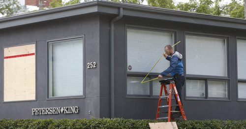 A window is measured up for a piece of plywood Monday at the law office at 252 River Ave. where a bomb exploded injuring a lawyer last week. Wayne Glowacki / Winnipeg Free Press July 6  2015