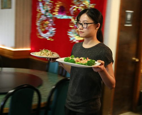 Owners daughter Serena Li serves up a dish at Dragon Palace at 3060 Portage Ave. Photographed for restaurant review. Photo by Jason Halstead/Winnipeg Free Press