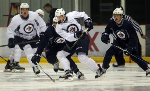 Jimmy Lodge, centre, clears the puck at Winnipeg Jets Prospects Camp at the MTS Iceplex Tuesday-See Tim Campbell story- July 07, 2015   (JOE BRYKSA / WINNIPEG FREE PRESS)