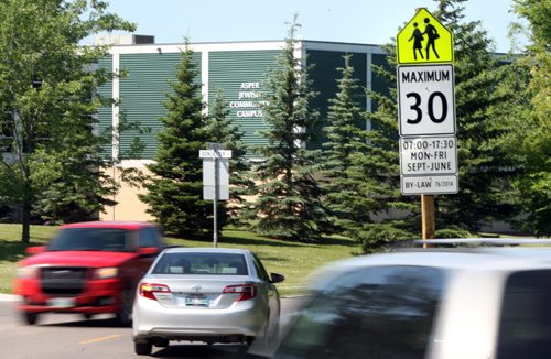 Traffic on Wellington Cr. near Doncaster St. pass a school zone sign with the Asper Jewish Community Campus in back Wayne Glowacki / Winnipeg Free Press July 7  2015