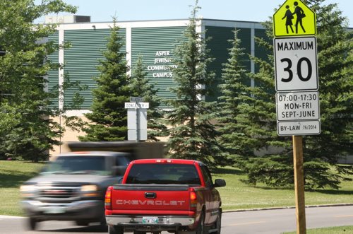 Traffic on Wellington Cr. near Doncaster St. pass a school zone sign with the Asper Jewish Community Campus in back Wayne Glowacki / Winnipeg Free Press July 7  2015