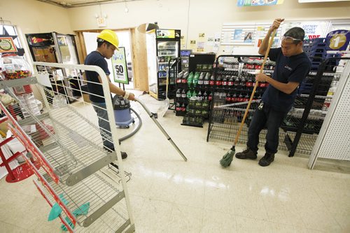 July 7, 2015 - 150707  -  Restoration crew cleans up after a truck crashed through the window of a Munroe Avenue convenience store Tuesday, July 7, 2015. The truck ran over a young boy who was pulled to safety by his dad. John Woods / Winnipeg Free Press
