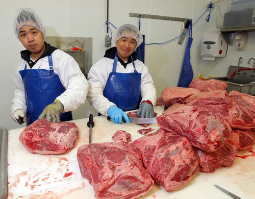 (L-R) Brothers Jason and Ryan Garces work. They are recent R.B. Russell School grads who now work as meat cutters in To-Le-Dos main production plant. Its for a story on the need for more meat cutters and the ongoing challenge of attracting young people to the trade. BORIS MINKEVICH/WINNIPEG FREE PRESS July 8, 2015