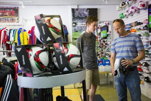 Alex Vonhof (left) and his dad, Maarten, decide on cleats at La Liga soccer shop in Winnipeg on Wednesday, July 8, 2015.   Mikaela MacKenzie / Winnipeg Free Press