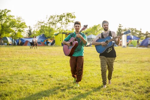 Christian Kuzdub (left) and Alexandre Joyal play guitar while walking through the folk fest campground at Birds Hill Park on Wednesday, July 8, 2015.   Mikaela MacKenzie / Winnipeg Free Press