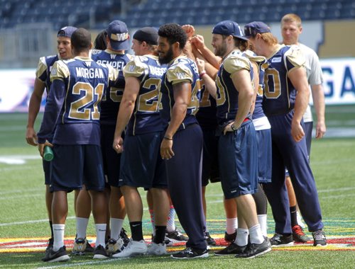 WINNIPEG BLUE BOMBERS WALK THROUGH PRACTICE AT THE STADIUM. Part of the team meets with the coach and then cheers. BORIS MINKEVICH/WINNIPEG FREE PRESS July 9, 2015
